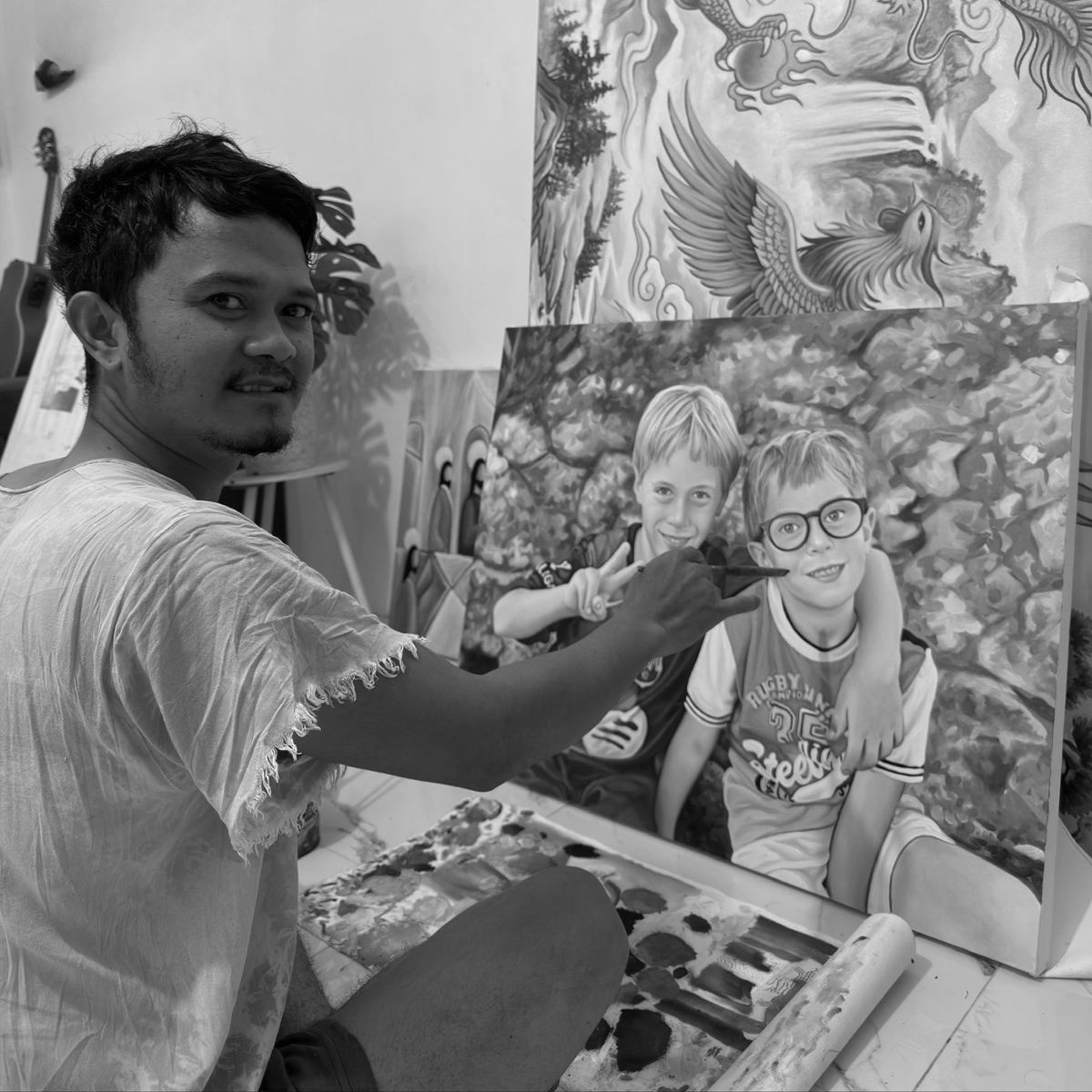 Artist Carlo Cruz, hand-painting a portrait from a photograph